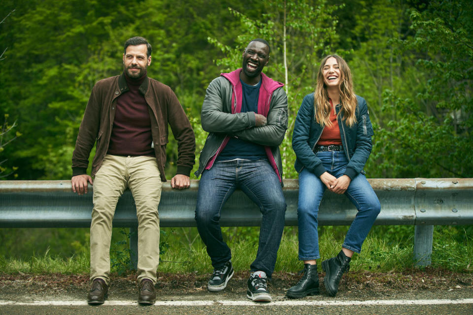 Omar Sy and Laurent Lafitte's characters leaning against a highway railing