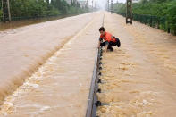 A worker checks a section of flooded railway in Shangrao in central China's Jiangxi province, Tuesday, June 21, 2022. Major flooding has forced the evacuation of tens of thousands of people in southern China, with more rain expected. (Chinatopix via AP)