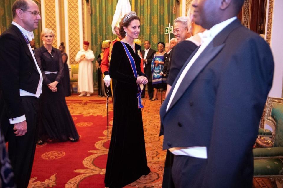 <p>The Duchess of Cambridge talks to guests at an evening reception for members of the Diplomatic Corps at Buckingham Palace. She wore a dress by <a href="https://www.alexandermcqueen.com/us" rel="nofollow noopener" target="_blank" data-ylk="slk:Alexander McQueen;elm:context_link;itc:0;sec:content-canvas" class="link ">Alexander McQueen</a>. </p>