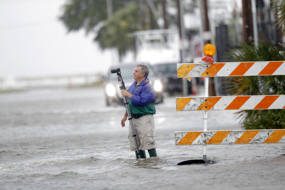 Charles Marsala, who lives in the Orleans Marina in the West End section of New Orleans, films a rising storm surge from Lake Pontchartrain, in advance of Tropical Storm Cristobal Sunday, June 7, 2020. (AP Photo/Gerald Herbert)