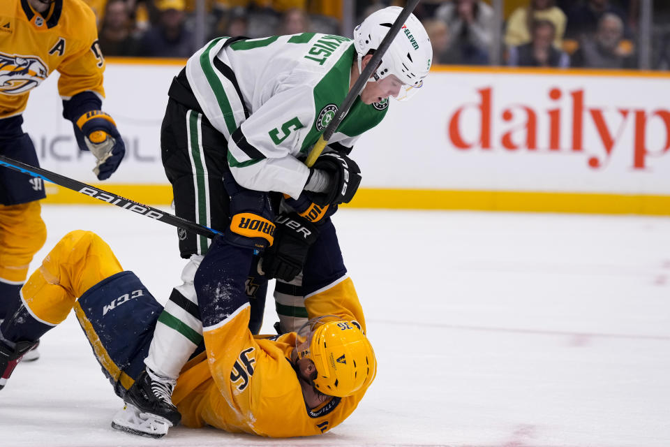 Dallas Stars defenseman Nils Lundkvist (5) and Nashville Predators left wing Cole Smith (36) fight during the second period of an NHL hockey game Thursday, Oct. 10, 2024, in Nashville, Tenn. (AP Photo/George Walker IV)