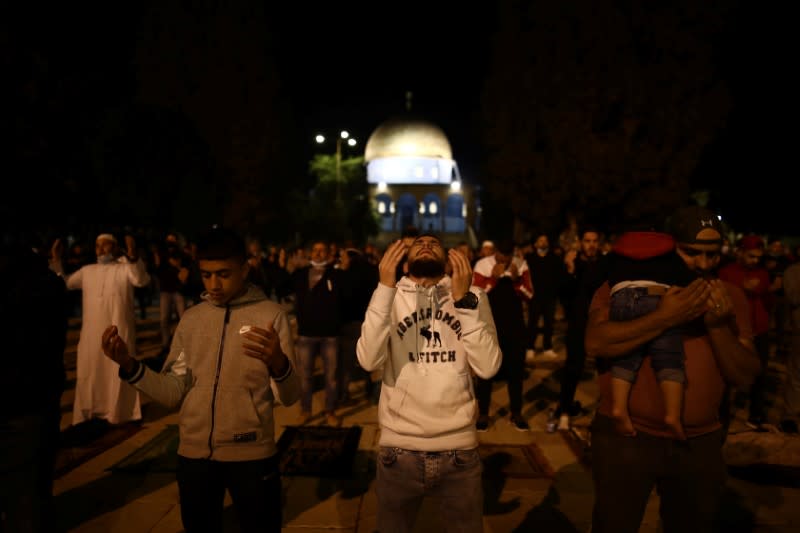 Worshippers pray in front of the Dome of the Rock in the compound known to Muslims as Noble Sanctuary and to Jews as Temple Mount in Jerusalem's Old City, after it was reopened following a coronavirus closure