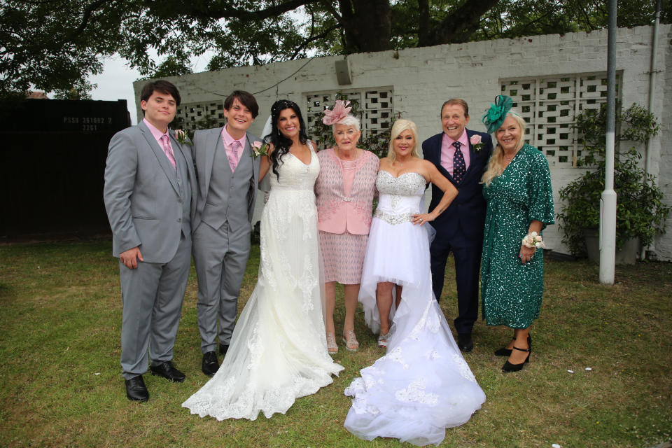 Brides Linda Birgitte Olsen and Samantha Fox pose with Linda's sons Adam and Noah and her mother Jorunn, along with Sam's step-father Colin Bryan and mum Carole Fox. (Fox Media via Getty Images )