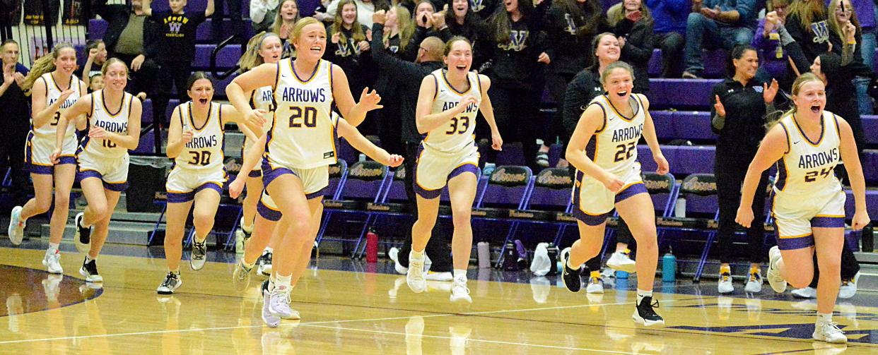 Watertown reserves, from left, Molly Hendricks (32), Emma Hendricks (10), Addy Huyvaert (30), Madisyn Grimsrud, Neely Johnson (20), Avery Munger (33), Grace Corey (22) and Jade Lund (24) storm the floor after the Arrows defeated Sioux Falls Lincoln in a SoDak 16 Class AA state-qualifying girls basketball game on Friday, March 3, 2023 in Watertown.