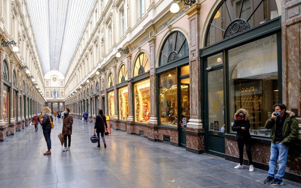 People walk in the near-empty Galeries Royales Saint-Hubert in Brussels - Thierry Monasse/Getty Images