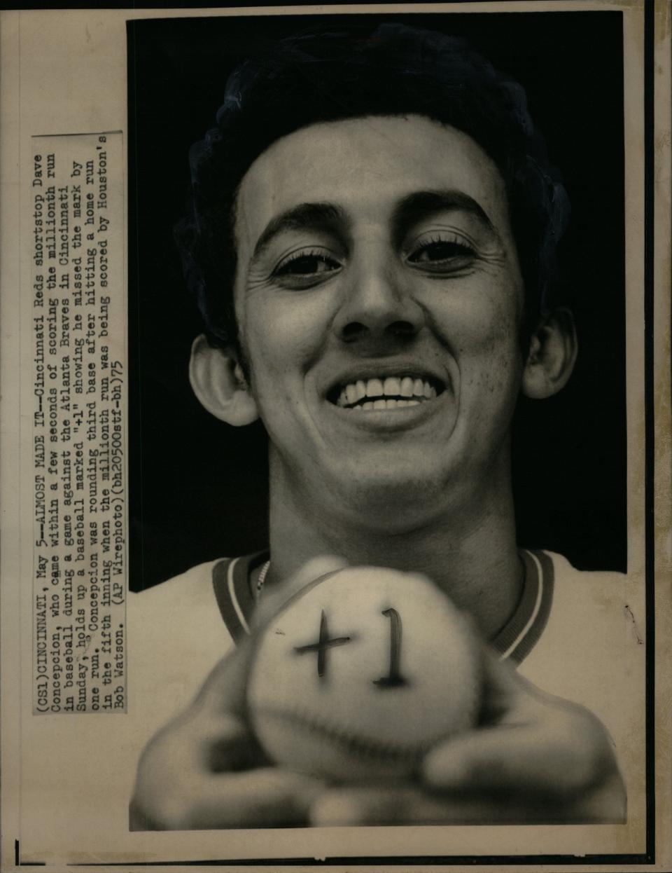 Cincinnati Reds shortstop Dave Concepcion, who came within a few seconds of scoring the millionth run in baseball during a game against the Atlanta Braves, holds up a baseball marked "+1" showing he missed the mark by one run.