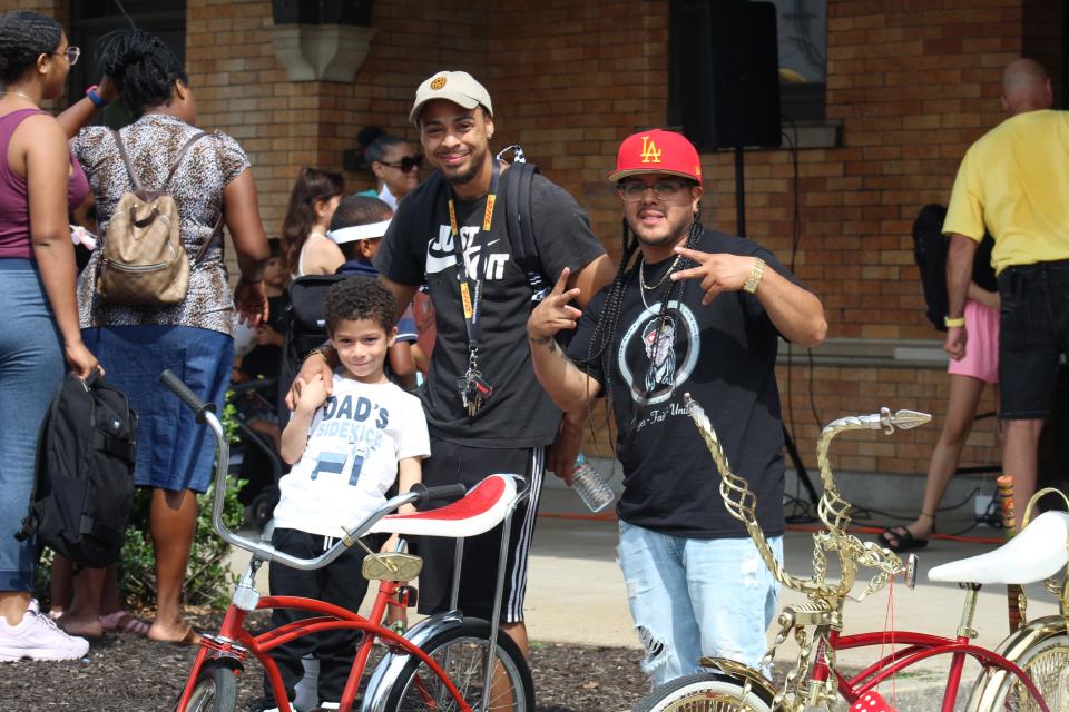 The custom lowrider on the left, built by Pedro Cartagena, right, was raffled off to Eric Rios and his son, Eric, left.