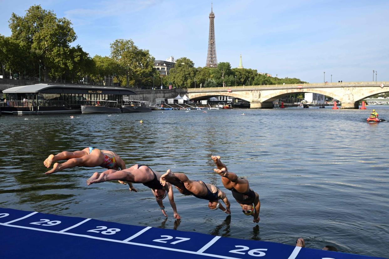<span>Athletes dive into the River Seine during the swim familiarisation event before triathlon test races in Paris last August.</span><span>Photograph: Bertrand Guay/AFP/Getty Images</span>