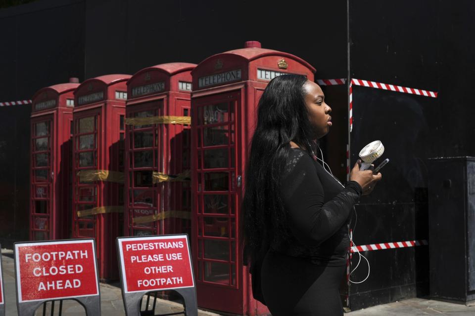 ARCHIVO - Una mujer se refresca con un ventilador de mano durante un día caluroso en Londres, el 26 de junio de 2024. (AP Foto/Kin Cheung, archivo)