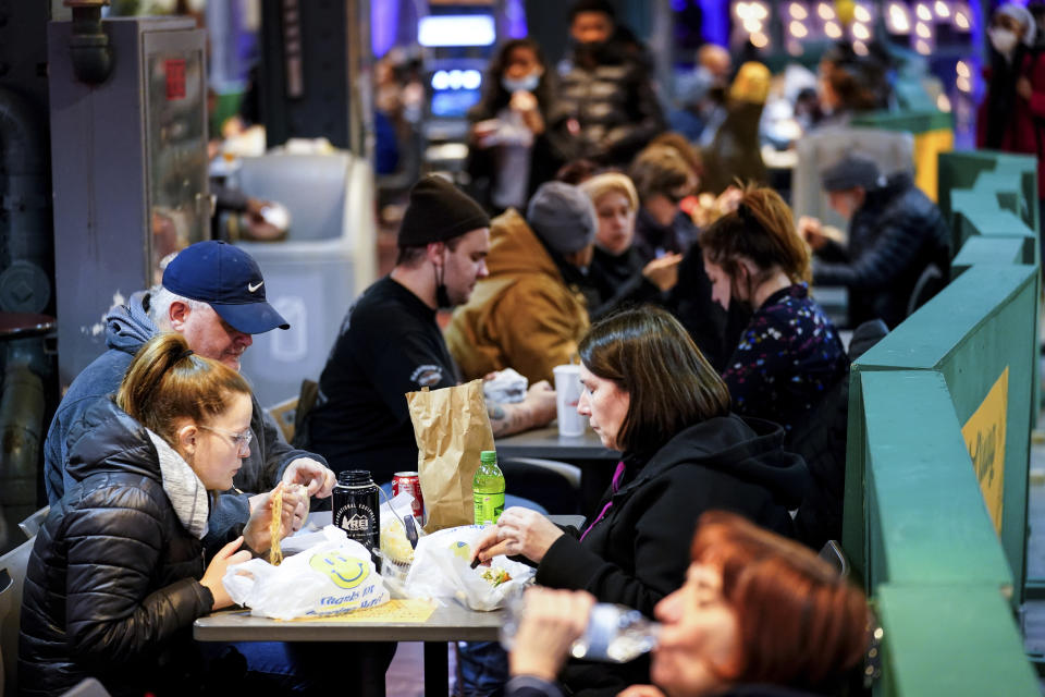 Customers eat at the Reading Terminal Market in Philadelphia, Wednesday, Feb. 16, 2022. Philadelphia city officials lifted the city's vaccine mandate for indoor dining and other establishments that serve food and drinks, but an indoor mask mandate remains in place. Philadelphia Public Health officials announced that the vaccine mandate was lifted immediately Wednesday. (AP Photo/Matt Rourke)