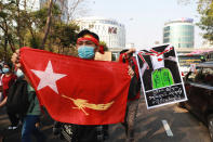 A protester holds a flag of deposed Myanmar leader Aung San Suu Kyi's National League for Democracy party as they march in the streets of Yangon, Myanmar on Sunday, Feb. 7, 2021. Thousands of people rallied against the military takeover in Myanmar's biggest city on Sunday and demanded the release of Aung San Suu Kyi, whose elected government was toppled by the army that also imposed an internet blackout. (AP Photo)