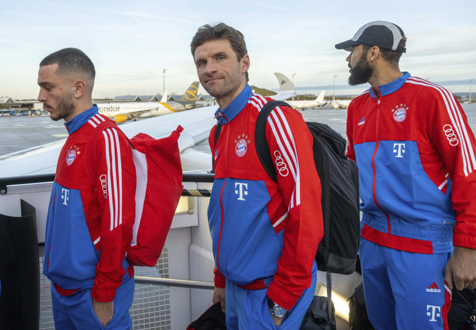 Thomas Mueller, center, and Eric Maxim Choupo-Moting, right, players of the Bundesliga soccer team FC Bayern Munich, board a plane at the airport in Munich, Gemany, Friday, Jan. 6, 2023. The Bayern Munich team flies to Qatar on Friday for its winter training camp amid uncertainty over the club’s contentious sponsorship agreement with the Persian Gulf country. (Peter Kneffel/dpa via AP)