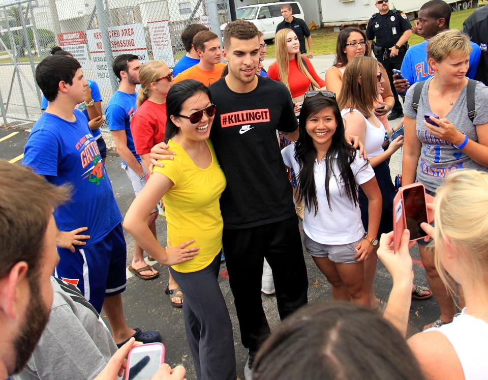Florida's senior Scottie Wilbekin poses for photos with fans at the Gainesville Regional Airport after returning home following the teams loss in the NCAA tournament semi-finals, in Gainesville on April 6, 2014. About 50 fans greeted the team at the airport.