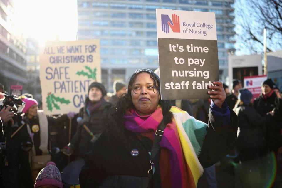 15 December 2022: NHS nurses hold placards during a strike, amid a dispute with the government over pay, outside St Thomas' Hospital in London (Reuters)