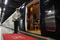 <p>A crew member stands next to one of the entrances to the Train Suite Shiki-shima at Ueno Station in Tokyo. (Photo: STR/AFP/Getty Images) </p>