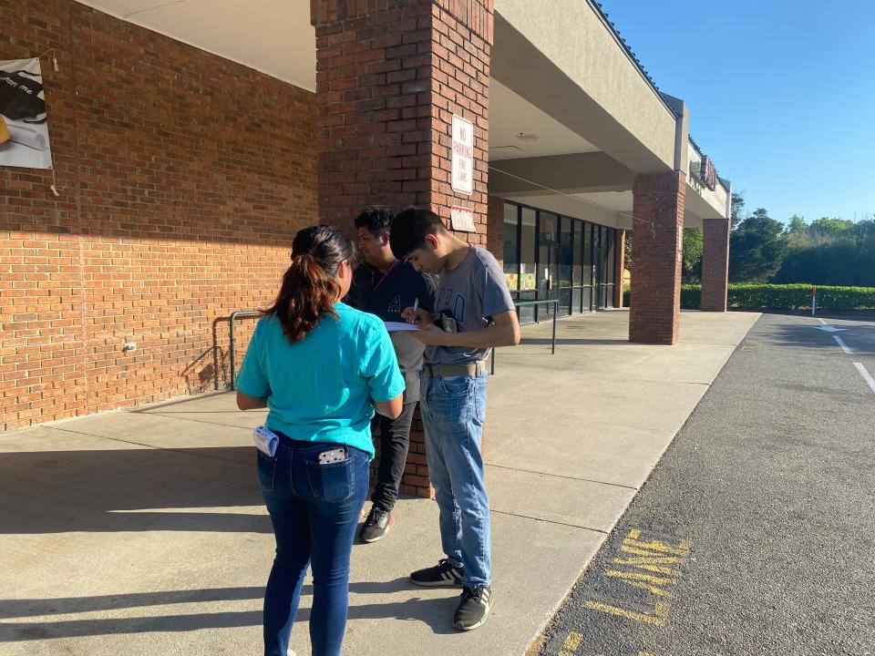 Maria Franco, a volunteer with Siembra, registering two voters outside a grocery store in Johnston County, NC