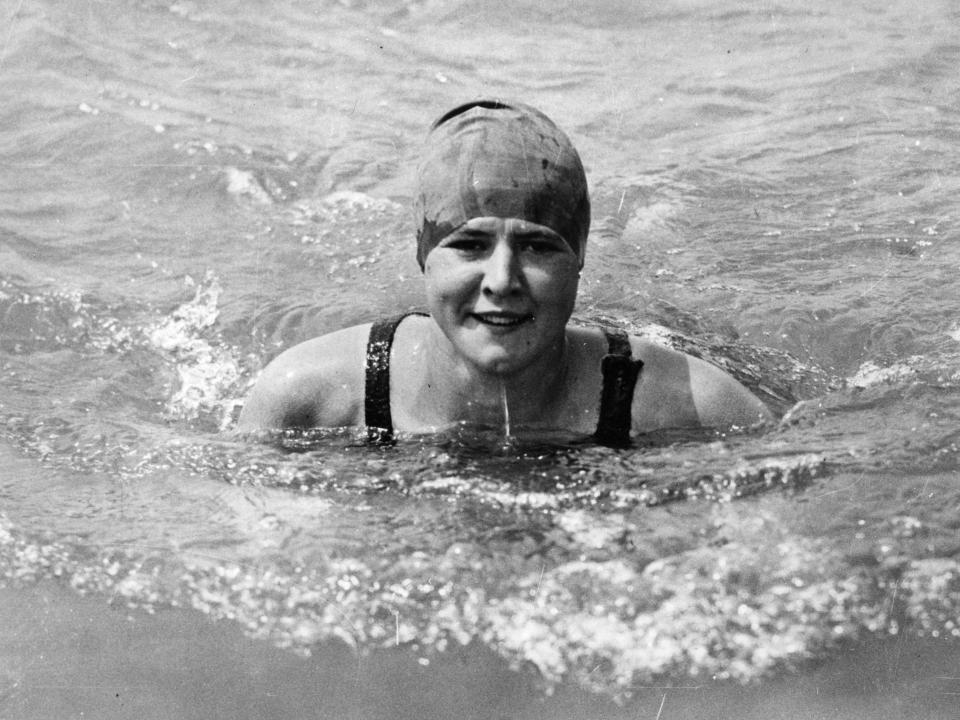 Getrude Ederle in the water with a swim cap on her head.