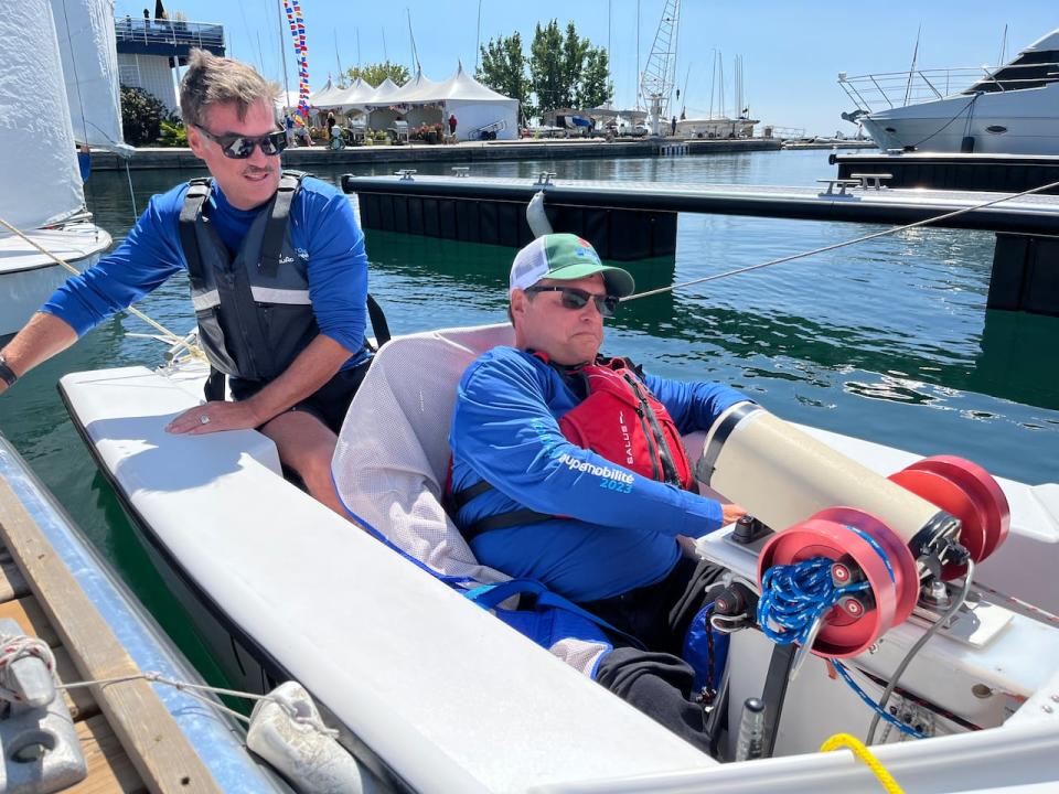 Robert Muzzy, who has cerebral palsy, prepares to disembark using an adapted boat on Aug. 28, 2023. A joystick tiller helps sailors steer the vessel, while electronic buttons allow them to control the sails. The adapted boats also have heavier keels to give them more stability and prevent tipping.