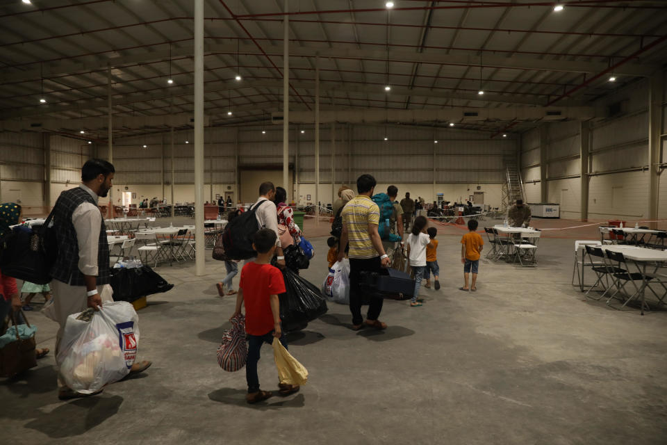 In this handout provided by the U.S. Army, evacuees from Afghanistan file through a processing building at Camp As Sayliyah on August 20, 2021, in Doha, Qatar. / Credit: Jimmie Baker/U.S. Army via Getty Images