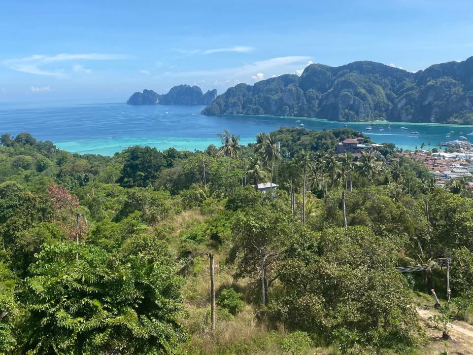 view of the water, mountains, and flora on the coast of thailand