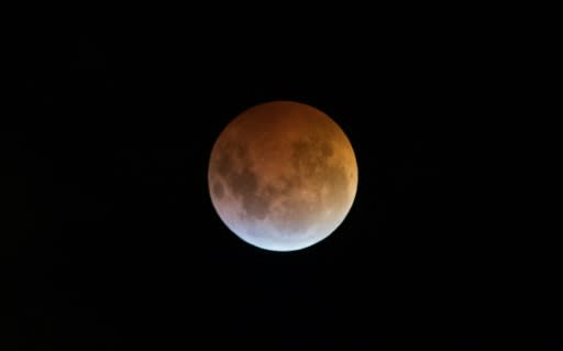 The Earth's shadow almost totally obscures the view of the so-called Super Blood Wolf Moon during a total lunar eclipse