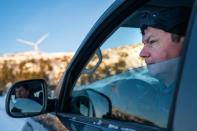 Leif Arne Jama, éleveur de rennes, pointe depuis sa voiture le parc à éoliennes de Storheia qu'il accuse d'empiéter sur ses terres ancestrales à Afjord en Norvège le 7 décembre 2021 (AFP/Jonathan NACKSTRAND)