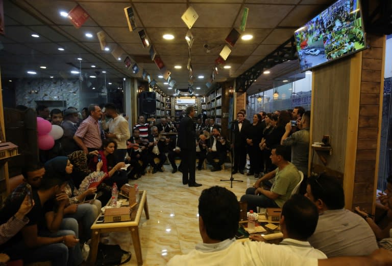 Iraqis watch a concert at the opening of a cafe-cum-bookshop in Baghdad's Karrada Dakhil street