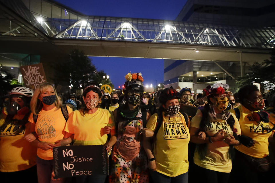 Demonstrators march during a Black Lives Matter protest Friday, July 24, 2020, in Portland, Ore. On the streets of Portland, a strange armed conflict unfolds night after night. It is raw, frightening and painful on both sides of an iron fence separating the protesters on the outside and federal agents guarding a courthouse inside. This weekend, journalists for The Associated Press spent the weekend both outside, with the protesters, and inside the courthouse, with the federal agents, documenting the fight that has become an unlikely centerpiece of the protest movement gripping America. (AP Photo/Marcio Jose Sanchez)