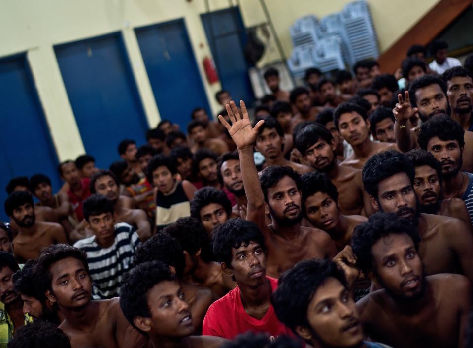 Bangladeshi migrant raises his hand for clothes as they wait at the Police headquarters in Langkawi on May 11, 2015 after landing on Malaysian shores earlier in the day. (MANAN VATSYAYANA/AFP/Getty Images)
