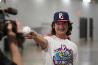 Braylon Sheffield, 14, of Fort Myers, Fla., shows one of the balls given to him by New York Yankees' Oswald Peraza as Sheffield is interviewed after the first baseball game of a doubleheader between the Yankees and Texas Rangers in Arlington, Texas, Tuesday, Oct. 4, 2022. Braylon caught Peraza's home run ball and they traded after the game. (AP Photo/LM Otero)