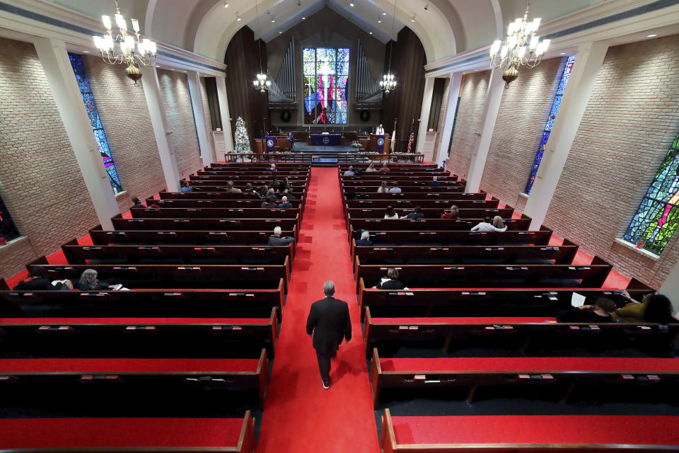 Rev. Meredith Mills delivers a sermon from the pulpit for some 30 attendants during the second service of the day in the sanctuary at Westminster United Methodist Church Sunday, Dec. 12, 2021, in Houston. Attendance for the two Sunday services is only about half of the average pre-pandemic turnout of about 160 or 170, Mills says. “It's better now than it was a year ago, but it's still frustrating,” she said. “People just seem to want to leave home less these days.” (AP Photo/Michael Wyke)