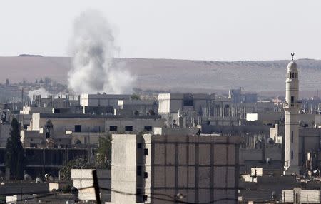 Smoke rises from the Syrian town of Kobani, seen from near the Mursitpinar border crossing on the Turkish-Syrian border in the southeastern town of Suruc, Sanliurfa province, October 5, 2014. REUTERS/Umit Bektas