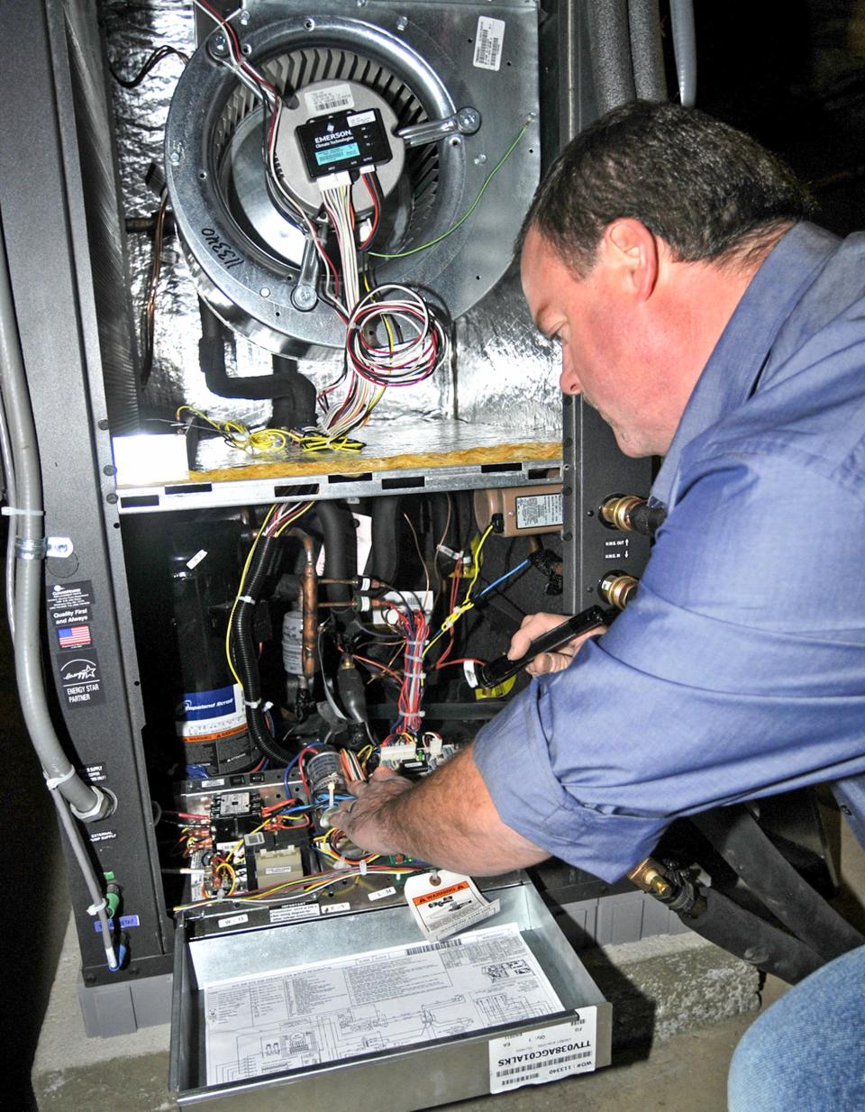 A technician looks over a newly installed geothermal heat pump system.