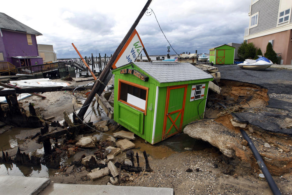 A small shop that rents personal water craft rests in a huge sinkhole on the bayside in Ocean City, N.J. Tuesday, Oct. 30, 2012 after a storm surge from superstorm Sandy Monday night. (AP Photo/Mel Evans)