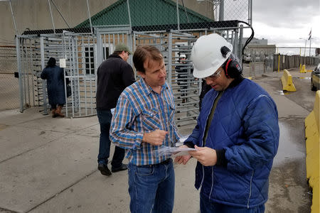 Democratic Party congressional candidate for the 1st district Alan LaPolice speaks with workers during a shift change at a meat packing plant about the move of polling places, in Dodge City, Kansas, U.S. October 26, 2018. REUTERS/John Whitesides