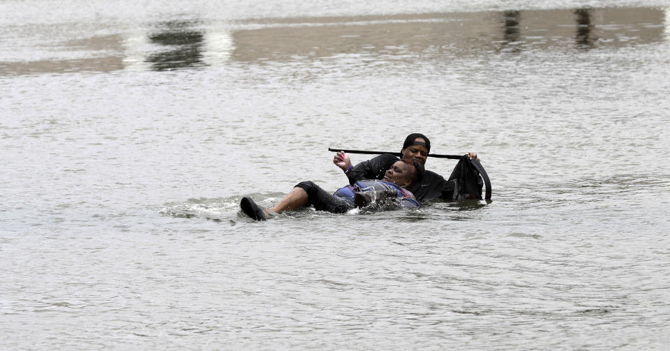 <p>Un hombre ayuda a una mujer en medio de la inundación en Houston, Texas. (AP Photo/David J. Phillip) </p>