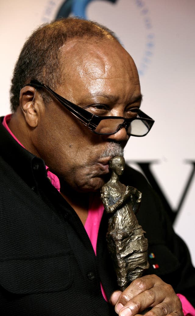 Quincy Jones kisses an award