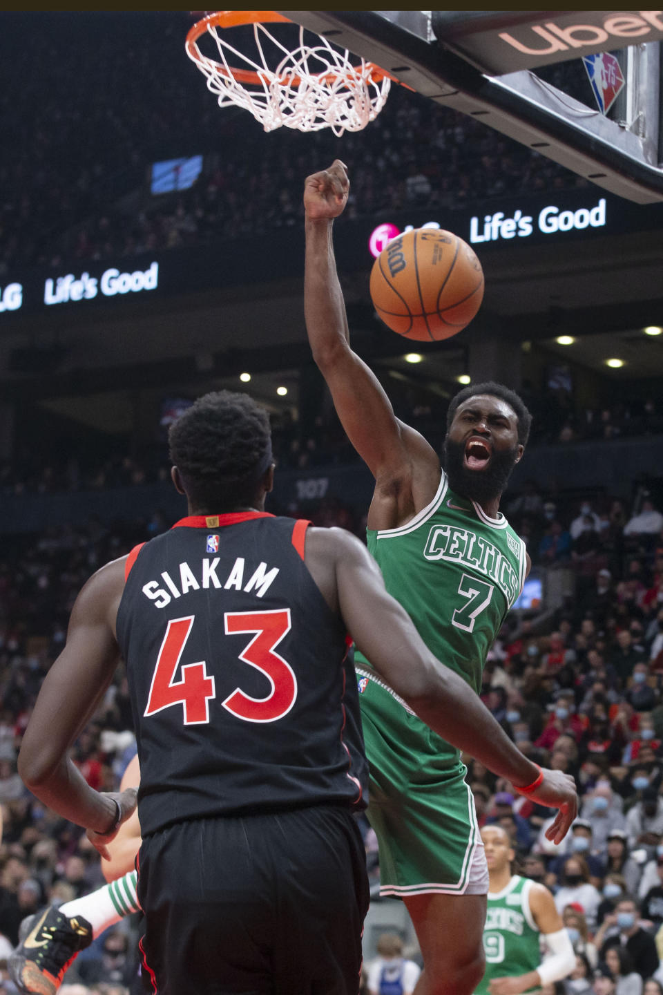 Boston Celtics' Jaylen Brown, right, scores as Toronto Raptors' Pascal Siakam looks on during the first half of an NBA basketball game in Toronto, Sunday, Nov. 28, 2021. (Chris Young/The Canadian Press via AP)