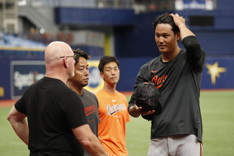 Baltimore Orioles relief pitcher Shintaro Fujinami, right, talks with assistant pitching coach Darren Holmes, left, during batting practice before playing against the Tampa Bay Rays in a baseball game Friday, July 21, 2023, in St. Petersburg, Fla. (AP Photo/Scott Audette)