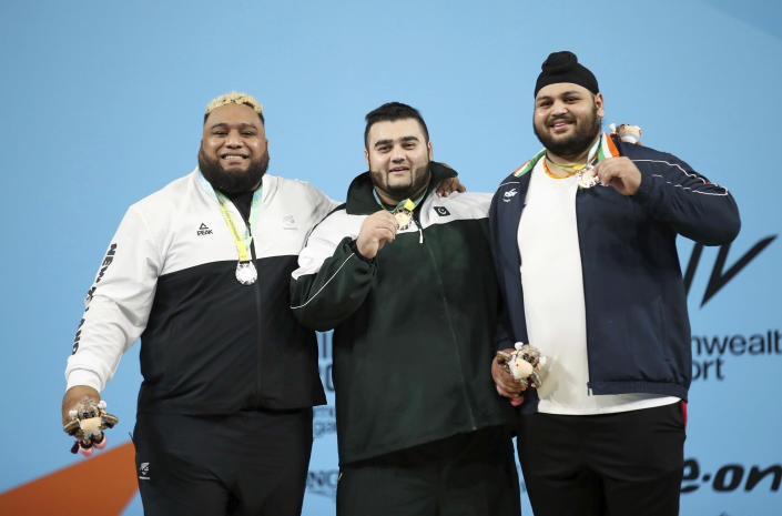 From left, New Zealand's David Andrew Liti, who won silver, Pakistan's Muhammad Noon Dastgir Butt who won gold and India's Singh Gurdeep who took the bronze, celebrate with their medals following the Men's 109kg+ final, at The NEC on day six of the 2022 Commonwealth Games in Birmingham, England, Wednesday, Aug. 3, 2022. (Isaac Parkin/PA via AP)
