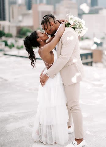 RAETAY PHOTOGRAPHY Simone Biles kissing husband Jonathan Owens on their wedding day in April 2023.