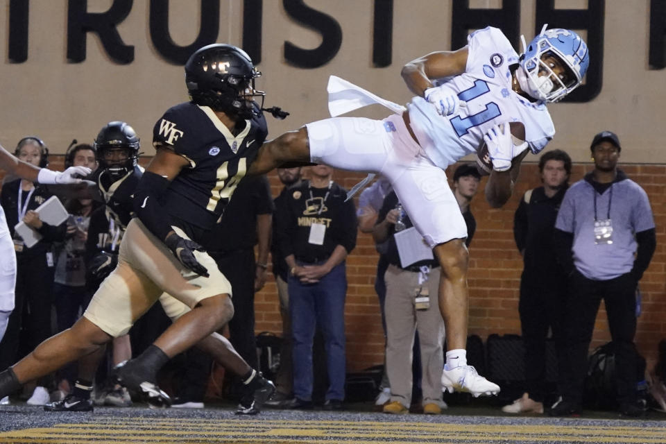North Carolina wide receiver Josh Downs (11) catches a touchdown pass as Wake Forest defensive back Evan Slocum (14) defends during the first half of an NCAA college football game in Winston-Salem, N.C., Saturday, Nov. 12, 2022. (AP Photo/Chuck Burton)