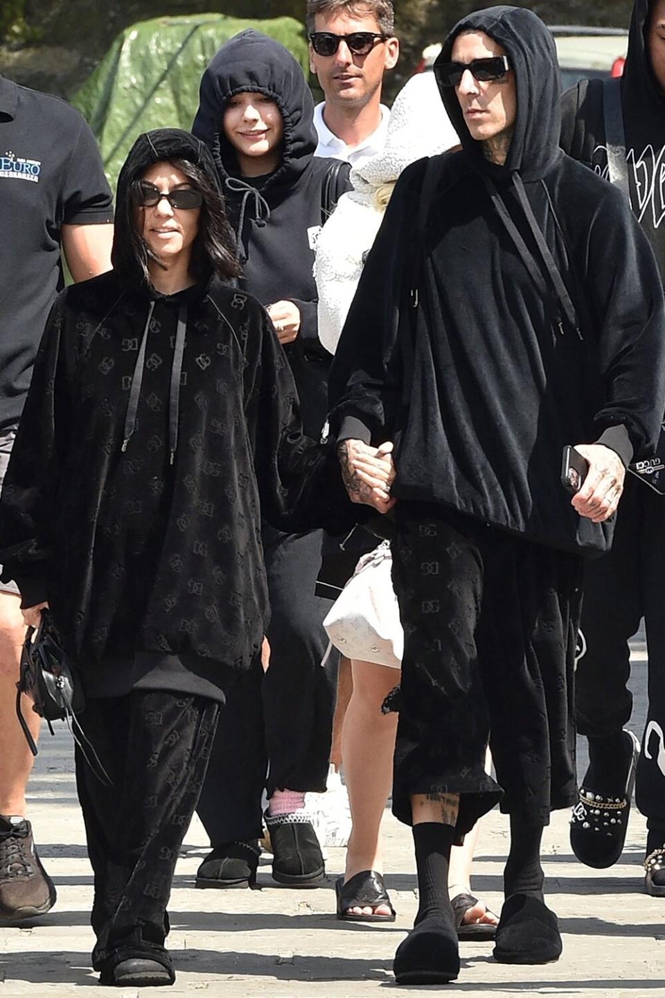 Honeymoon over? Newlyweds Kourtney Kardashian and husband Travis Barker are pictured wearing matching black Dolce and Gabbana velour tracksuits while seen departing Portofino