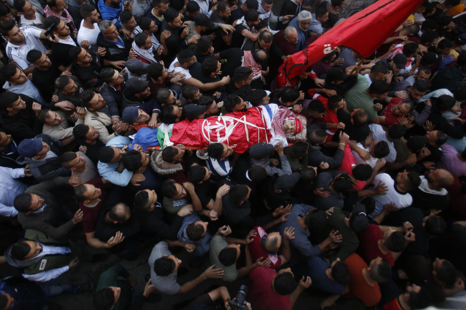 Palestinian mourners carry the body of Omar Badawi, 22, during his funeral at the al-Arroub refugee camp in the West Bank city of Hebron, Monday, Nov. 11, 2019. Badawi was shot in the chest during the confrontation with Israeli forces in the Aroub refugee camp, near the city of Hebron, on Monday afternoon. It gave no further details.(AP Photo/Majdi Mohammed)