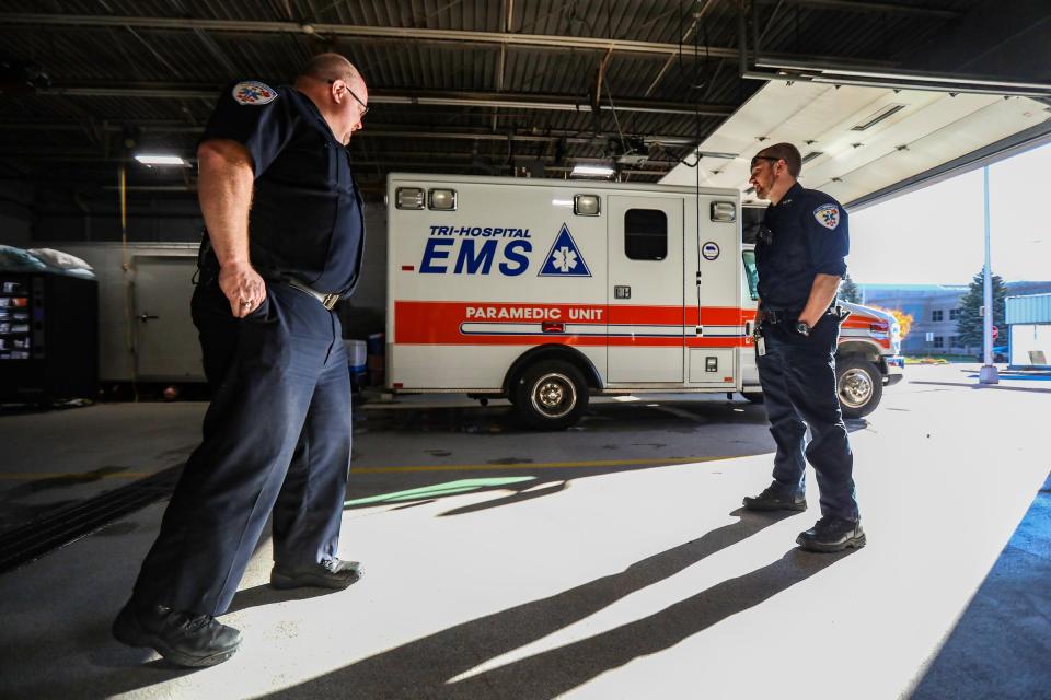 Paramedics Bill Adams, 46, left and Matt Biskner, 30, stand in the garage after responding to an emergency call at Tri-Hospital EMS in Port Huron on Nov. 19, 2021.