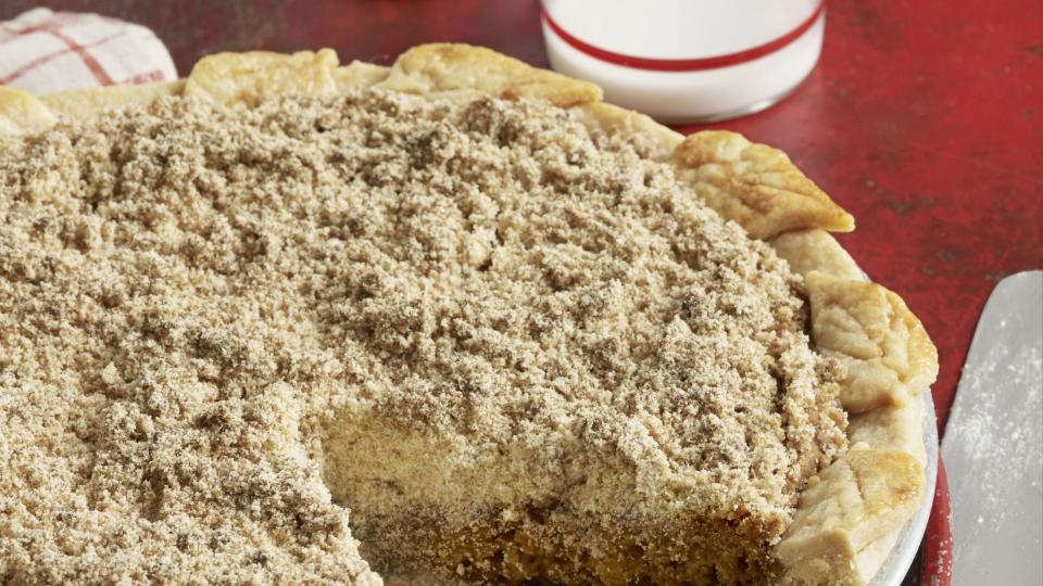 shoofly pie in a metal pie plate with a slice removed and a pie server next to it