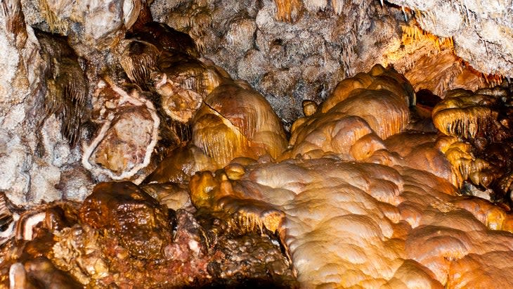 <span class="article__caption">The intricate surfaces within the cave at Jewel Cave National Monument, South Dakota</span> (Photo: Bernard Friel/UIG/Getty)