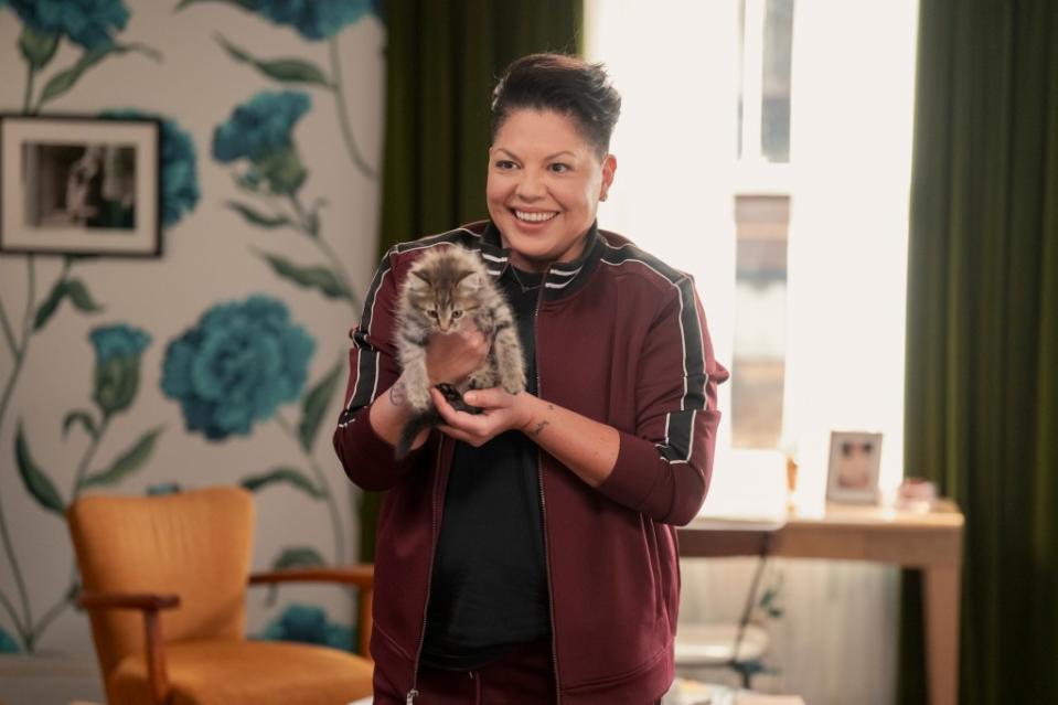 Che (Sara Ramirez) holding a kitten.