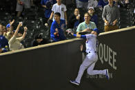 Chicago Cubs left fielder Ian Happ (8) chases a foul ball hit by Cincinnati Reds' Jake Fraley during the eighth inning of a baseball game, Wednesday, Sept. 7, 2022, in Chicago. (AP Photo/Matt Marton)