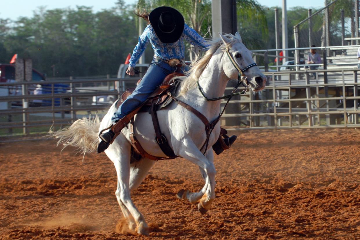 cowgirl riding a horse in a rodeo event